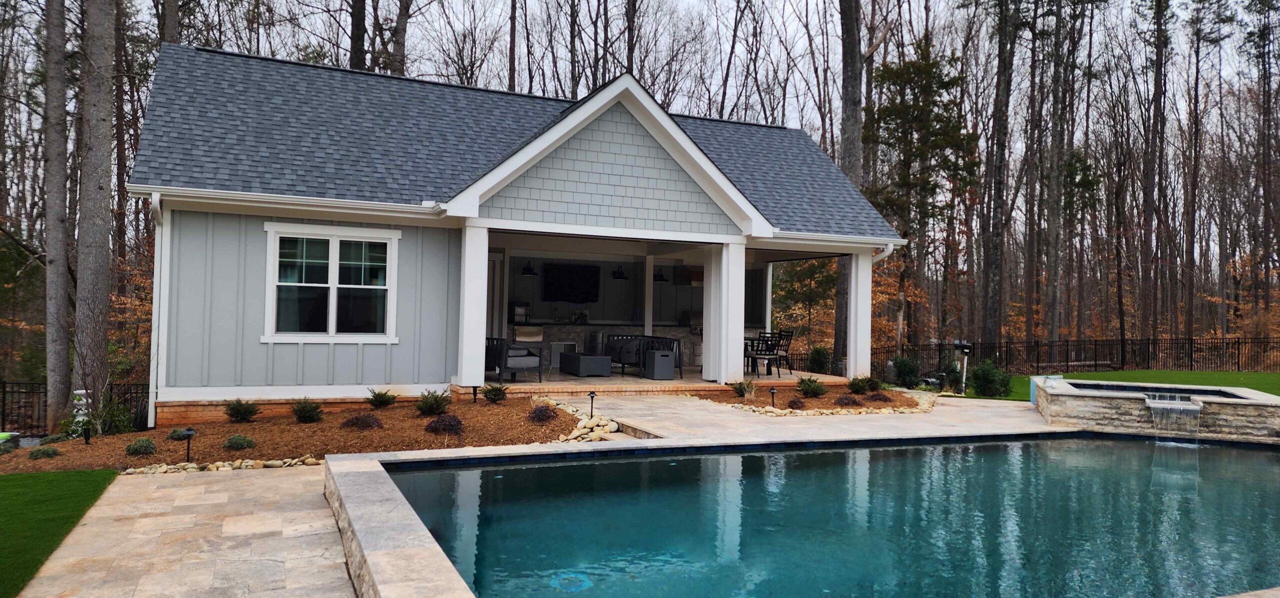 Beautiful pool house with guest bedroom and bathroom as well as an outdoor covered porch with grilling area